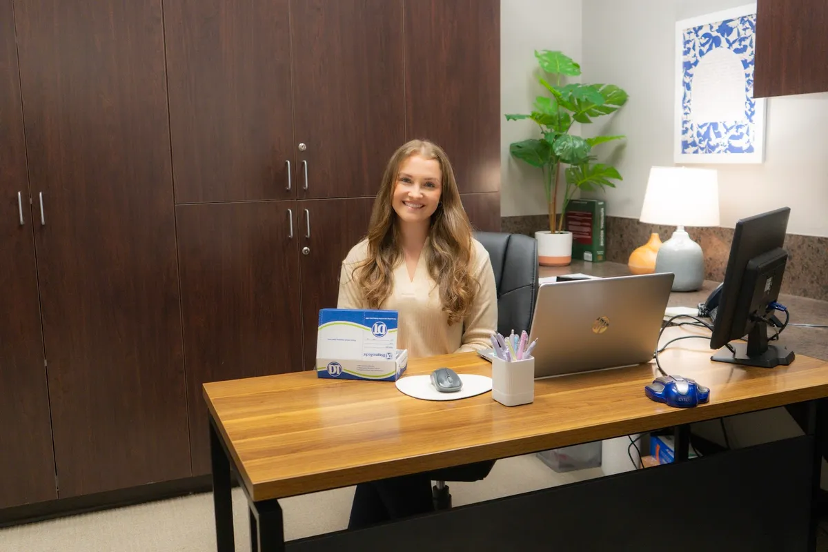 Raena at her desk with a testing kit