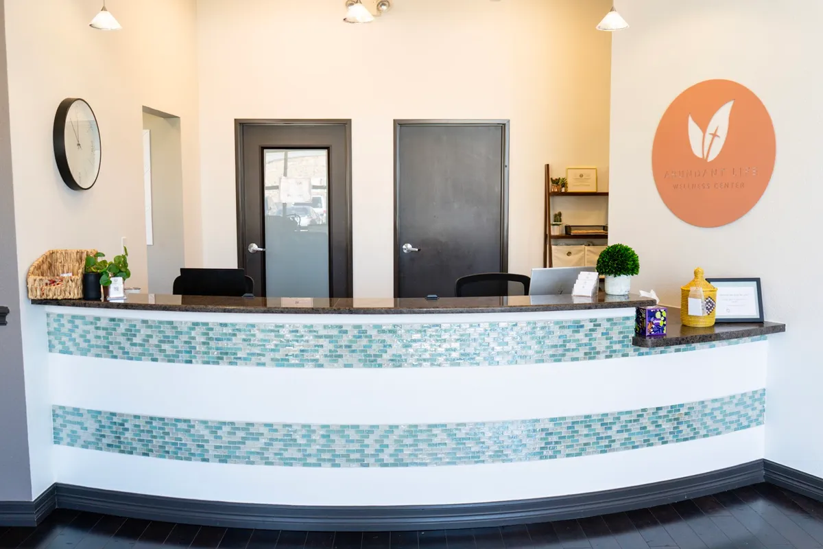 The reception desk with the practice's leaf-disc mark